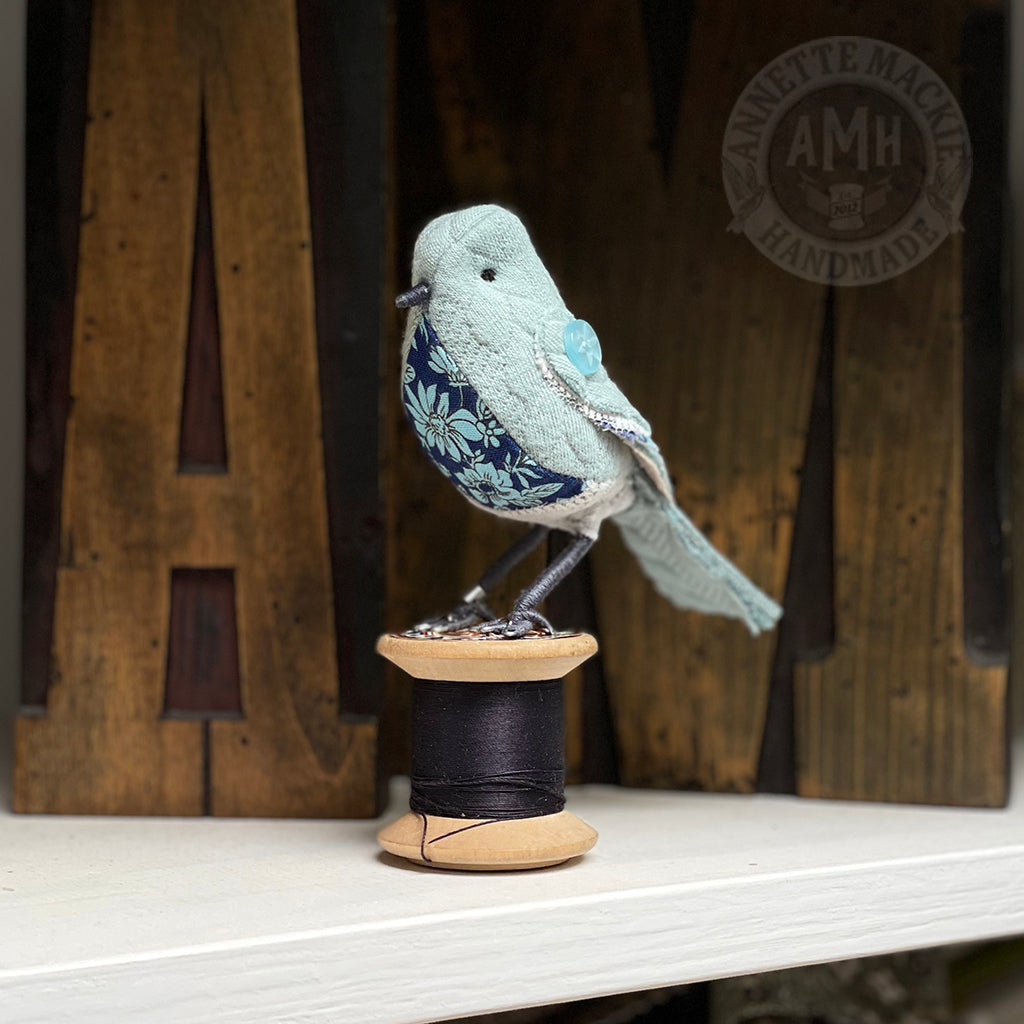 Mini bird on vintage reel