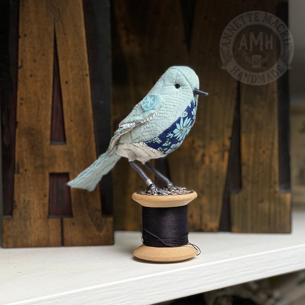 Mini bird on vintage reel