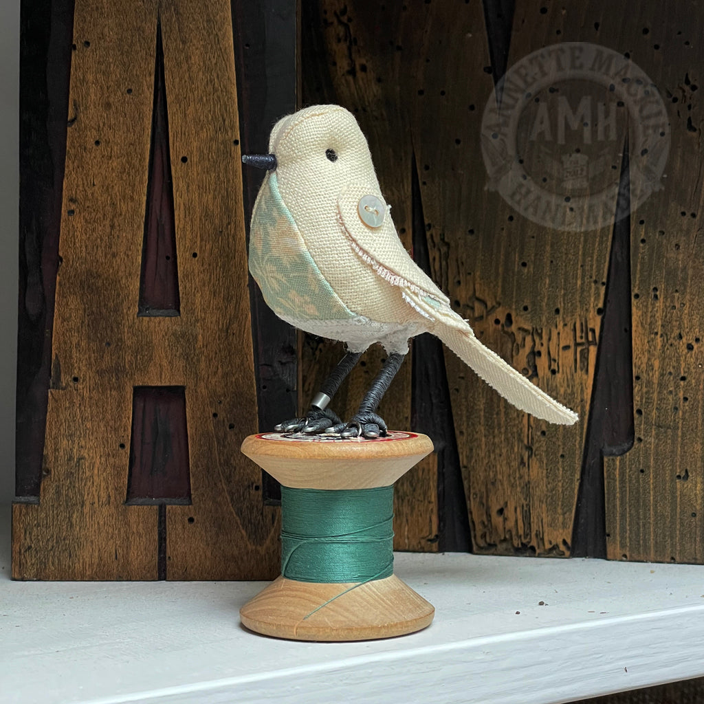 Mini bird on vintage reel