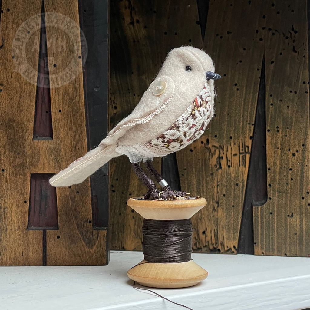 Mini bird on vintage reel