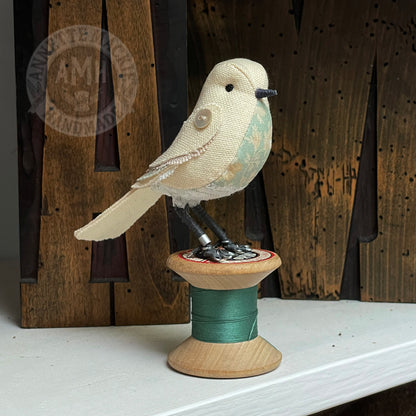 Mini bird on vintage reel