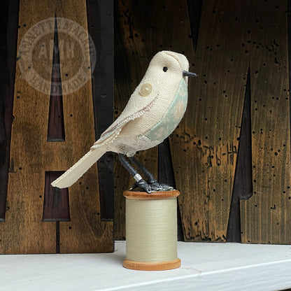 Mini bird on vintage reel