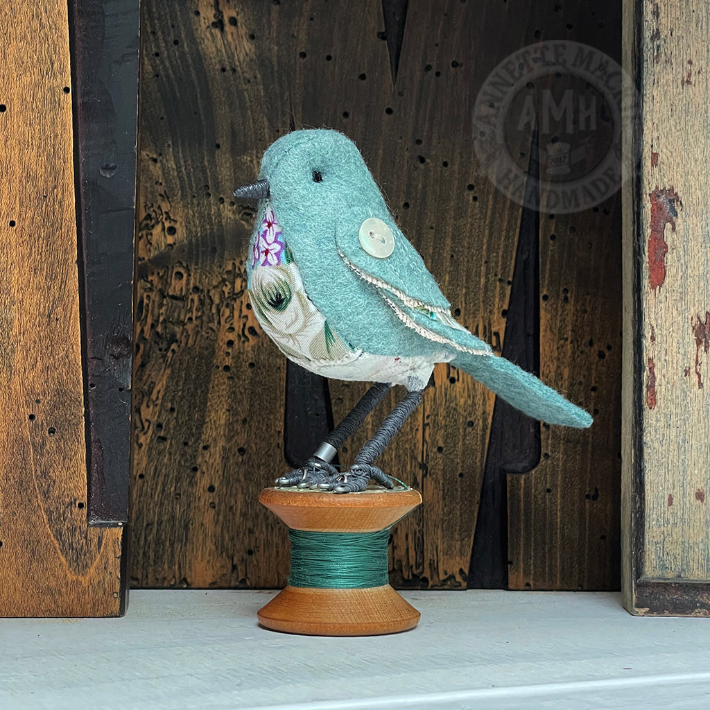Mini bird on vintage reel