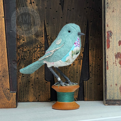 Mini bird on vintage reel