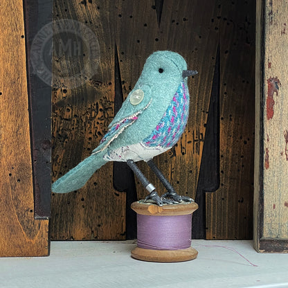 Mini bird on vintage reel