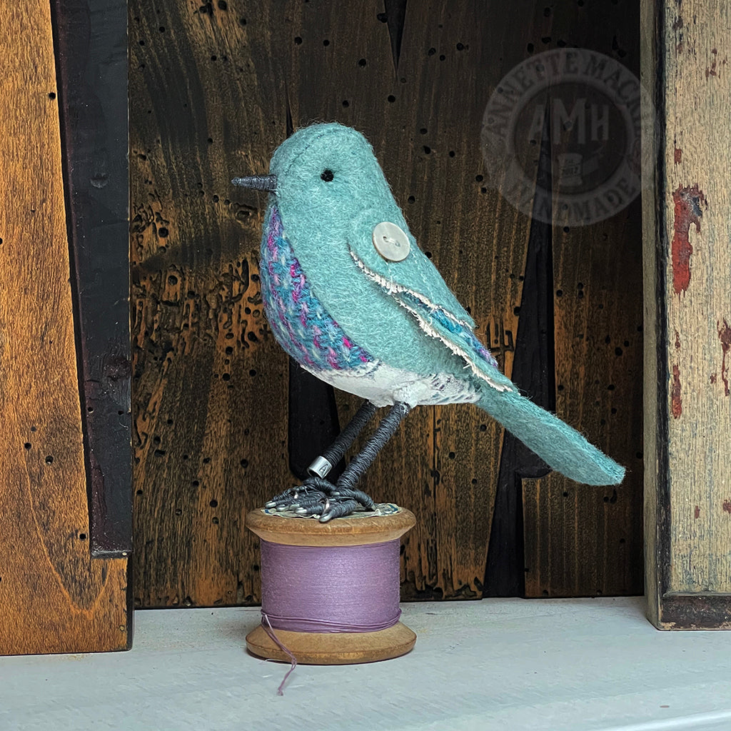 Mini bird on vintage reel