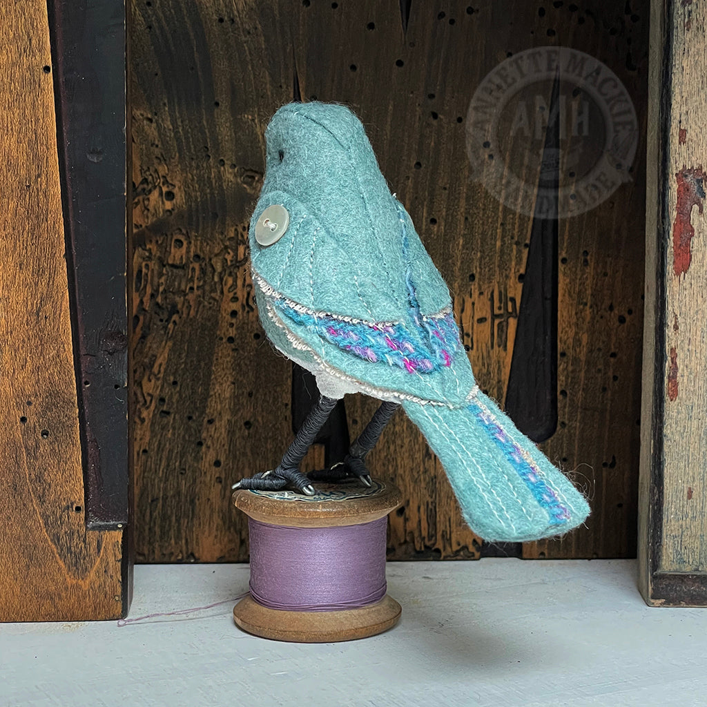 Mini bird on vintage reel