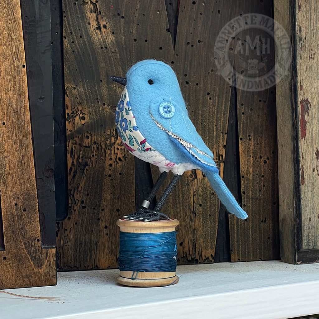 Mini bird on vintage reel