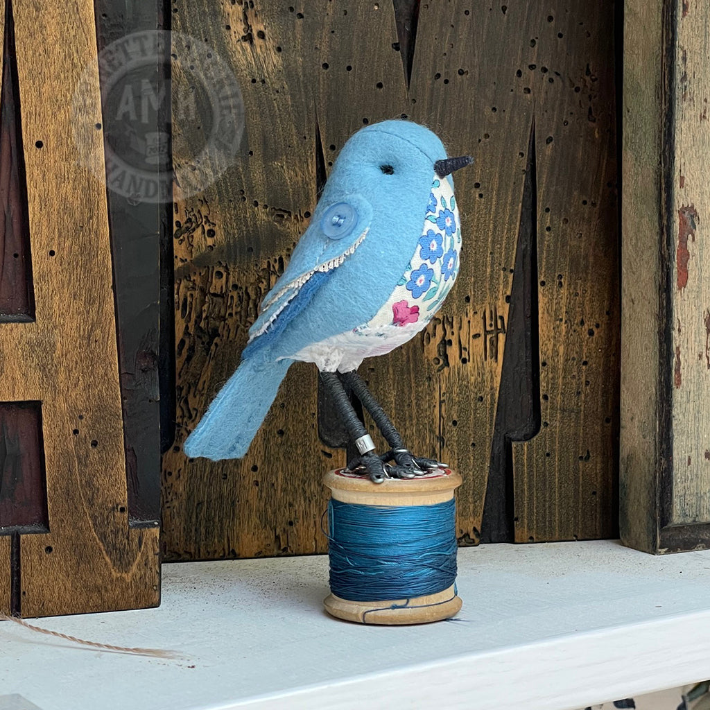 Mini bird on vintage reel