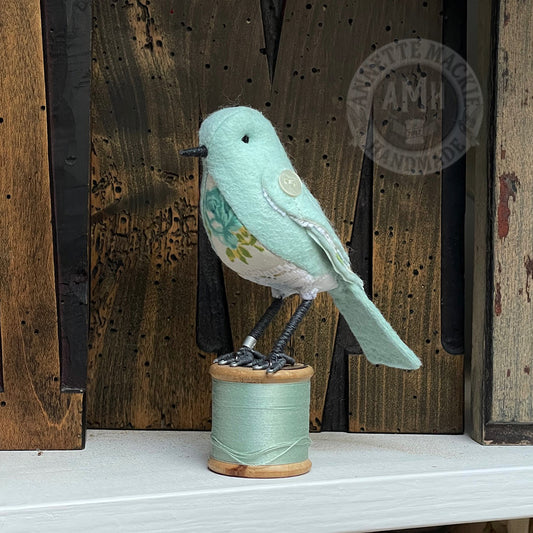 Mini bird on vintage reel