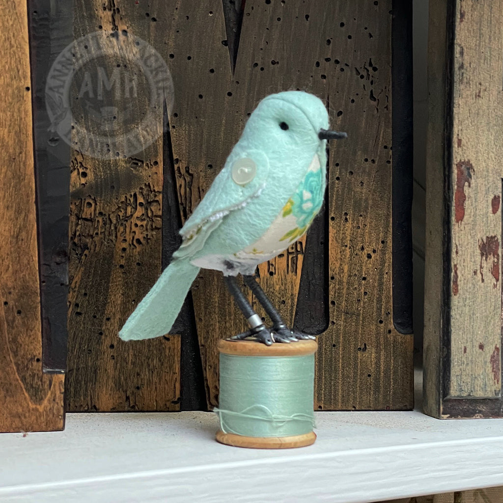 Mini bird on vintage reel